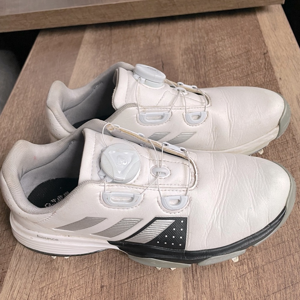 Adidas kids golf shoes with a swivel to tighten and loosen shoe (no shoelaces).